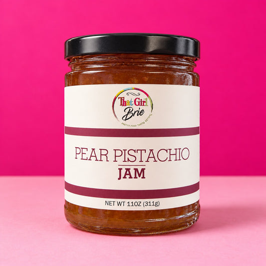 Pear pistachio jam in a That Girl Brie jar on a hot pink background