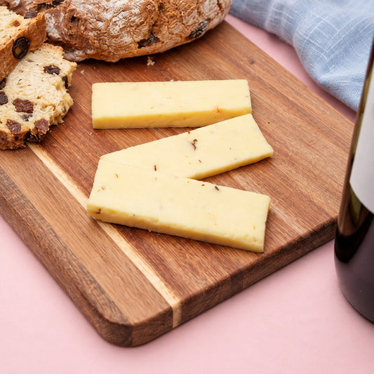 Slices of Portabella & Chive mushroom cheese on a cheese board with a blue linen napkin