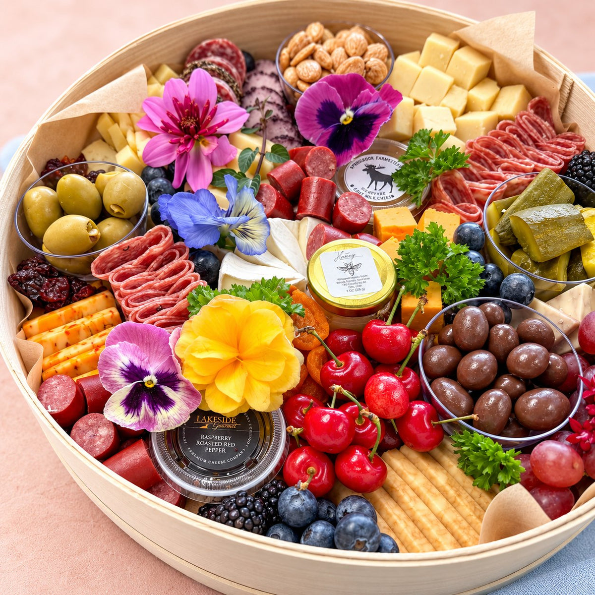 Close-up of a small Wisconsin cheese board with salami, cherries and edible flowers