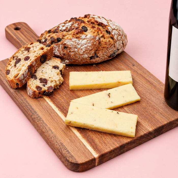 Cheese and wine pairing: sliced Wisconsin cheese on a board with raisin bread and red wine