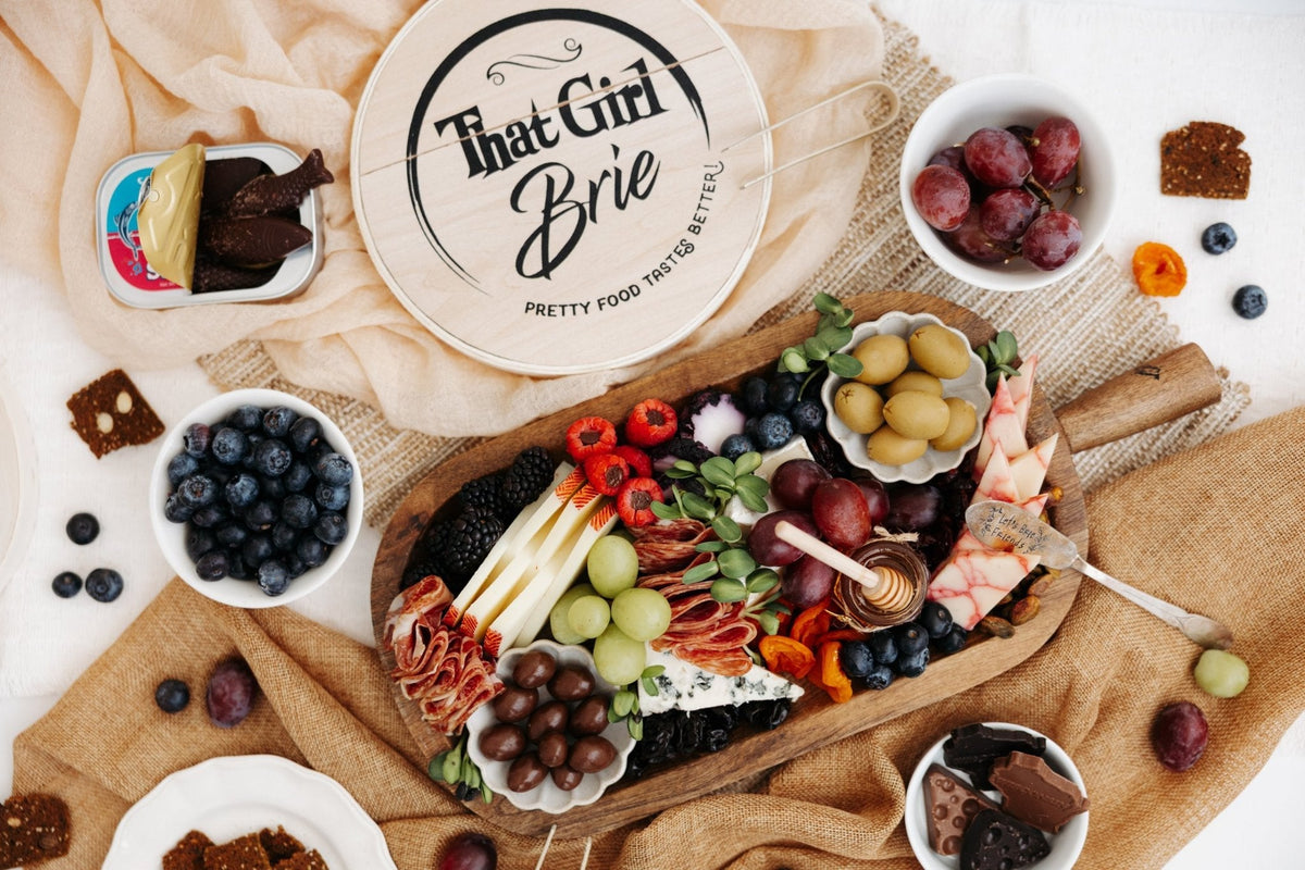Wisconsin cheese board flat lay with cheddar, salami and fruit from That Girl Brie in River Falls