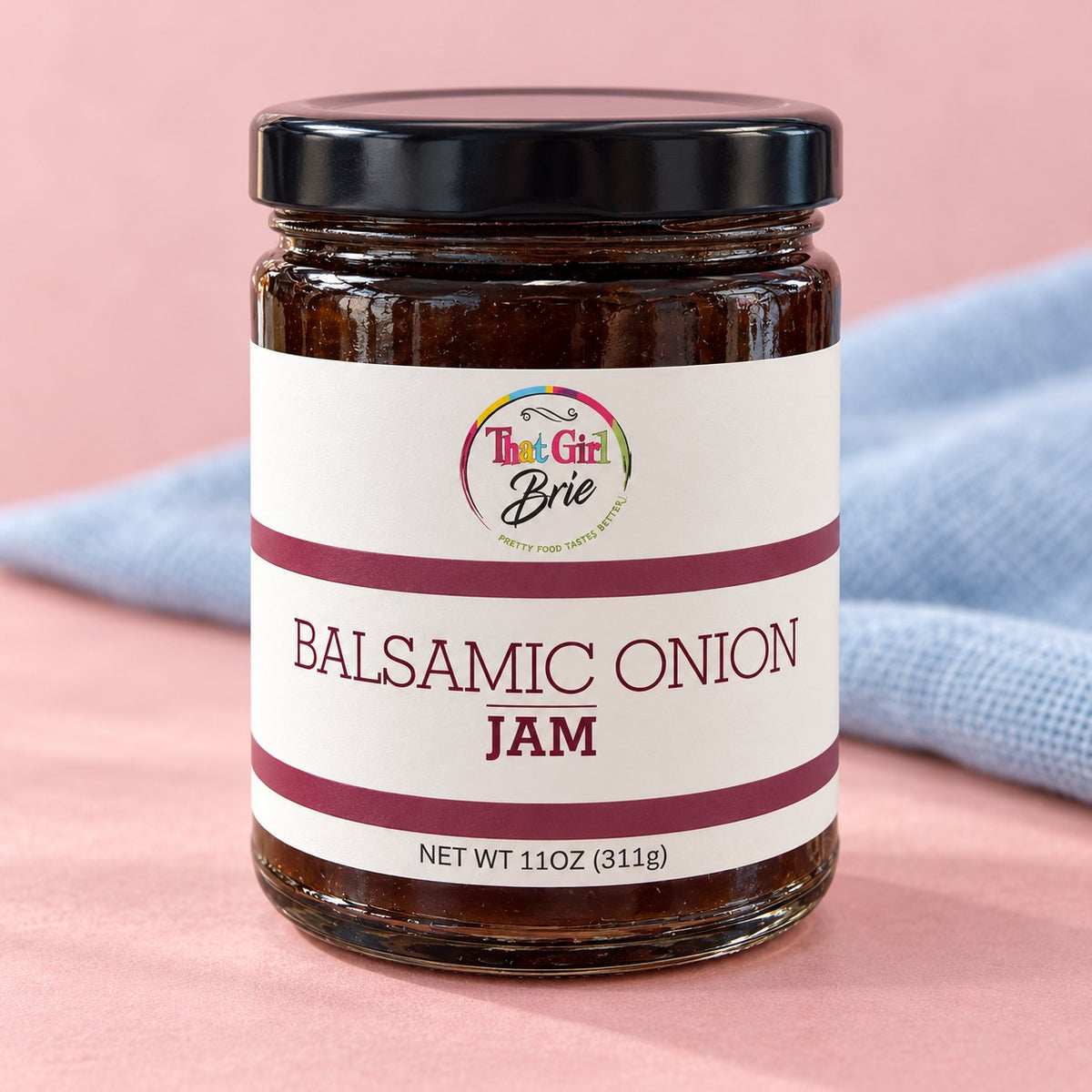Balsamic onion jam in a That Girl Brie jar with a blue linen napkin