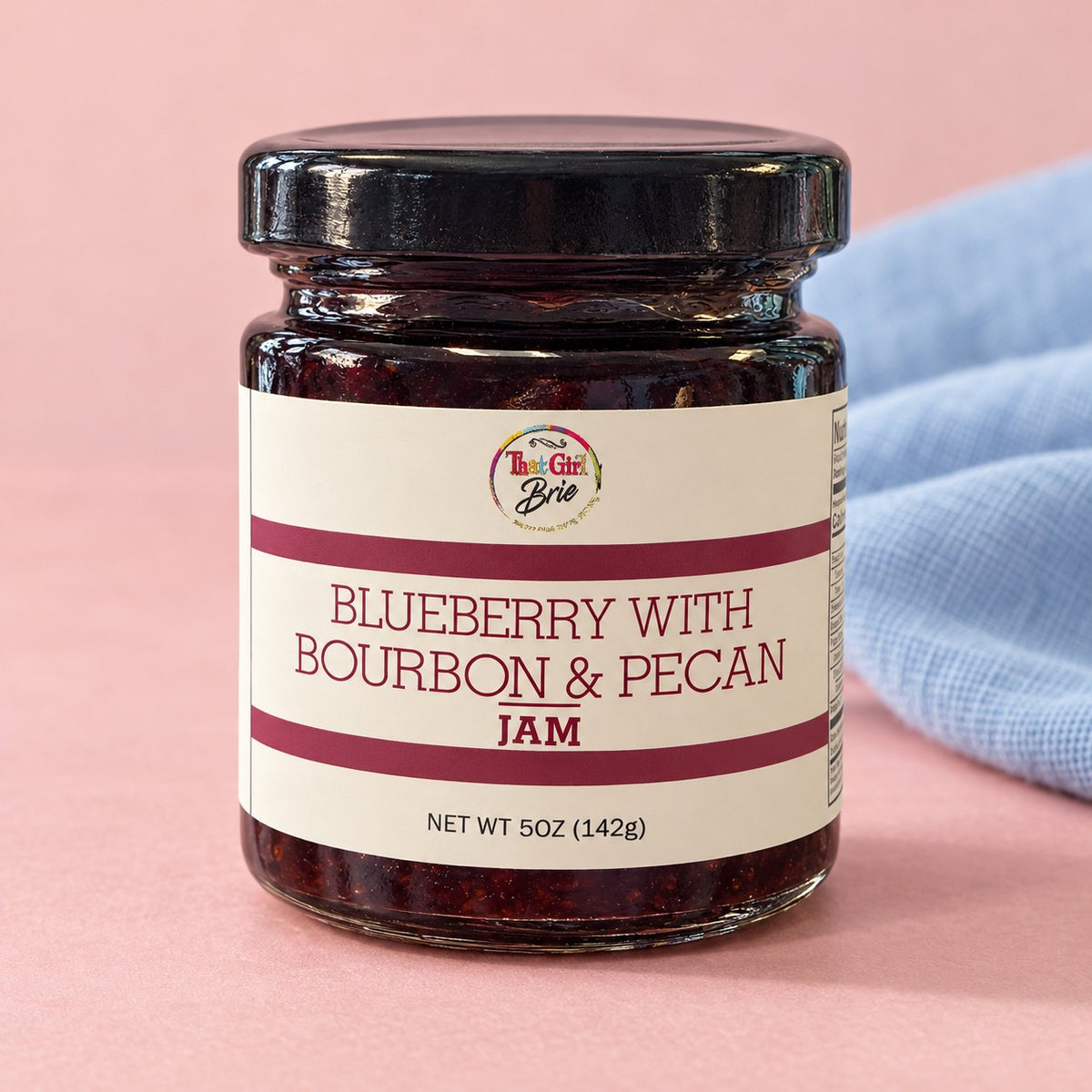 5 oz blueberry bourbon pecan jam jar with a blue linen napkin