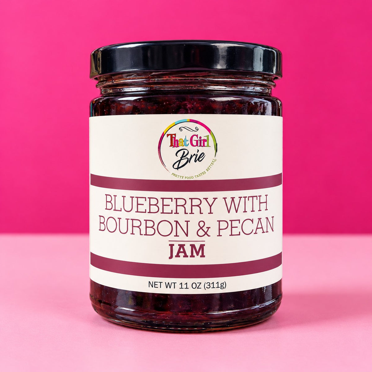 That Girl Brie blueberry bourbon pecan jam jar on a hot pink background