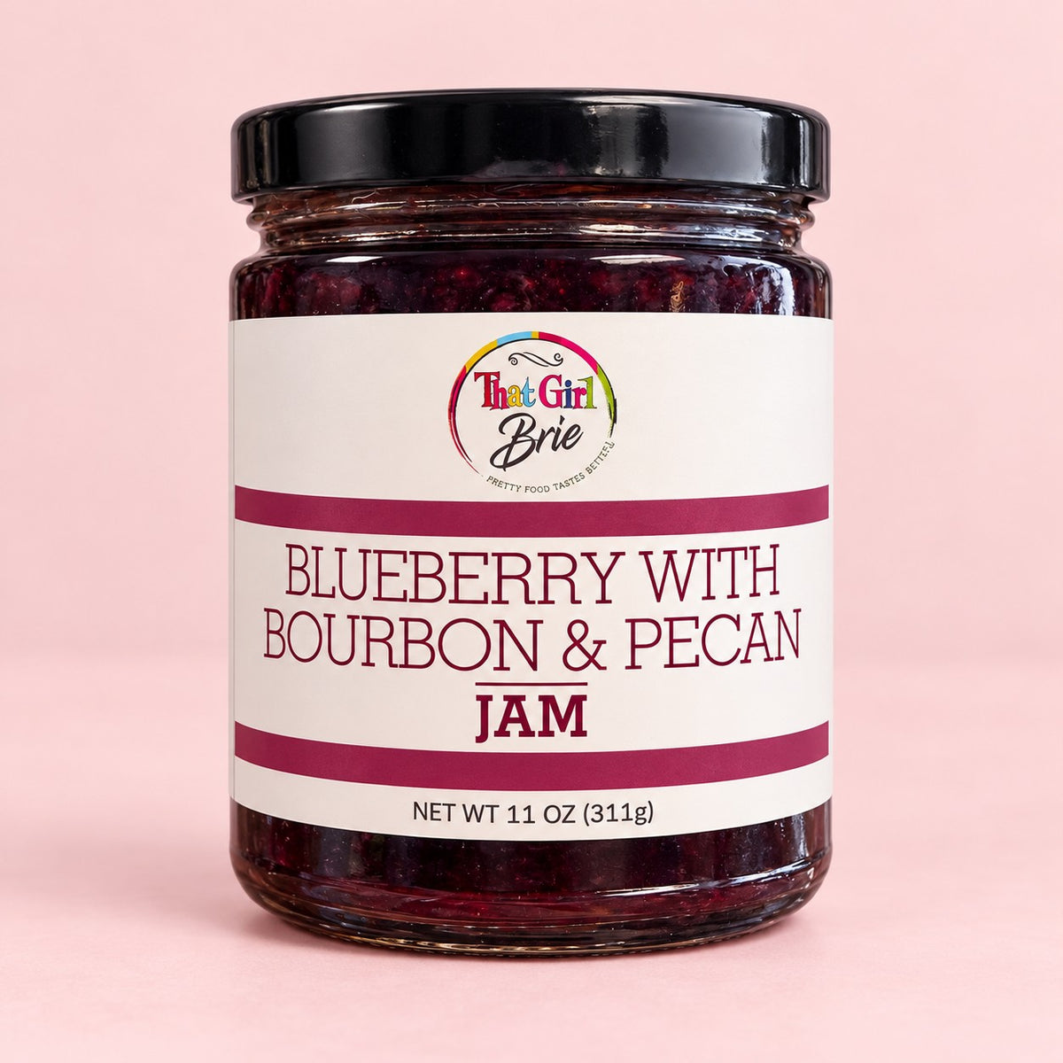 Jar of Blueberry with Bourbon & Pecan blueberry bourbon jam on a light pink background