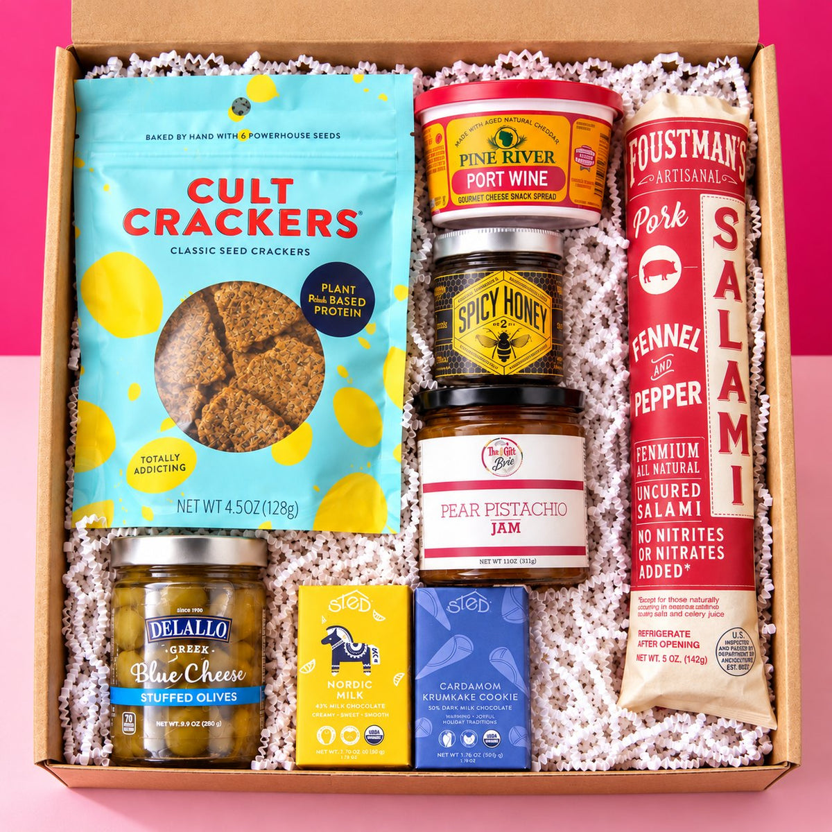 The Board Meeting charcuterie gift box on a hot pink background