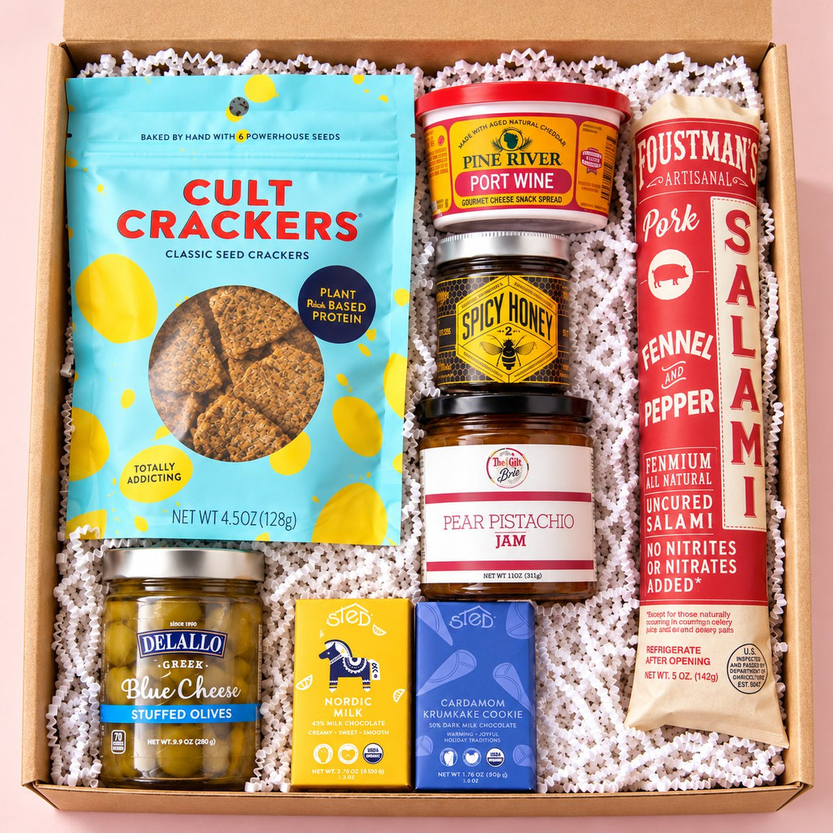 The Board Meeting shelf-stable charcuterie gift box on a light pink background