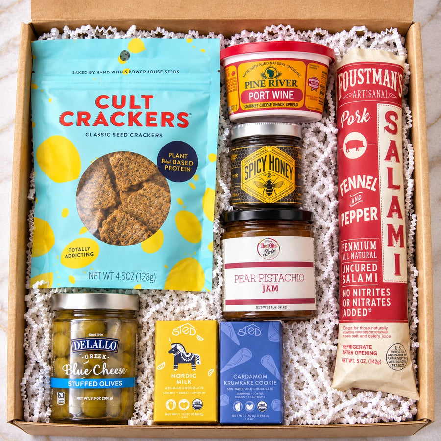 The Board Meeting charcuterie gift box with Foustman's salami, Cult Crackers, port wine cheese spread, spicy honey, pear pistachio jam, blue cheese olives and chocolate