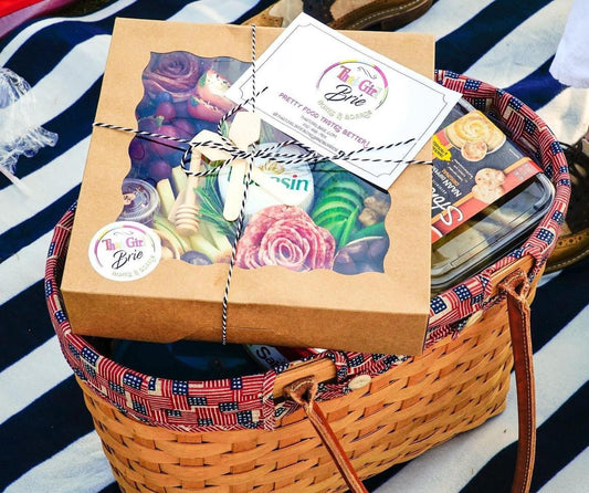 The Picnic Box charcuterie box tied with twine in a picnic basket