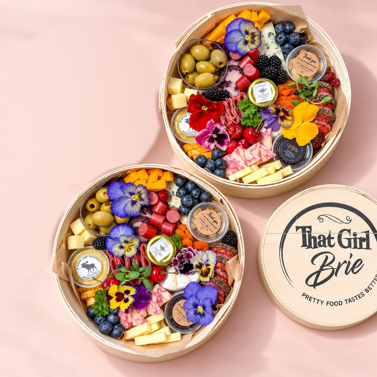 The Keepsake premium charcuterie board in two sizes, Signature and Grand Gift, with a That Girl Brie keepsake lid