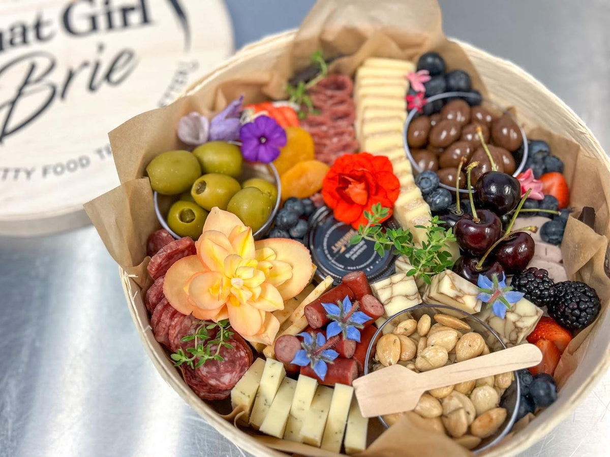 The Signature Keepsake 11 inch charcuterie board with olives, cherries, Wisconsin cheese and edible flowers in a wooden keepsake box