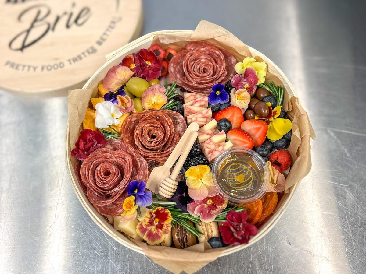 The Signature Keepsake 11 inch charcuterie board with salami roses, edible pansies, berries and honey in a That Girl Brie wooden box