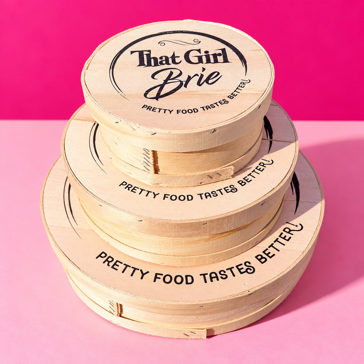 Keepsake wooden boxes with That Girl Brie lids, stacked in three sizes