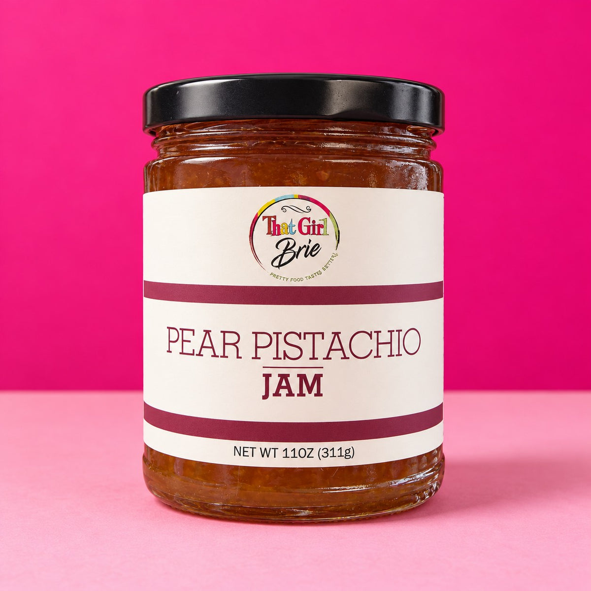 Pear pistachio jam in a That Girl Brie jar on a hot pink background
