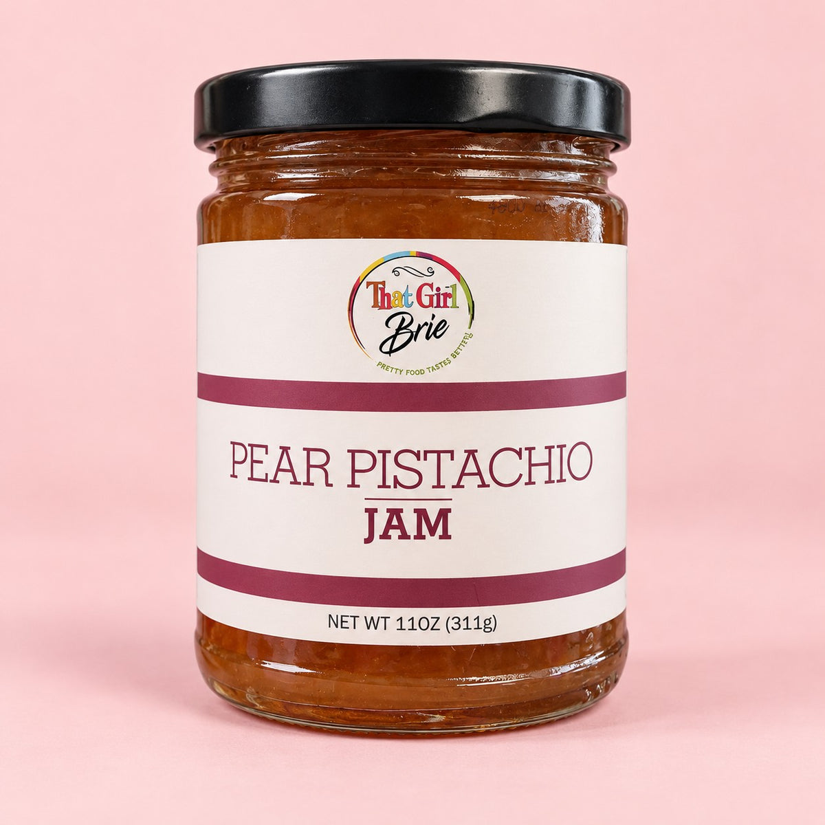 Jar of Pear Pistachio pear jam with pistachios on a light pink background