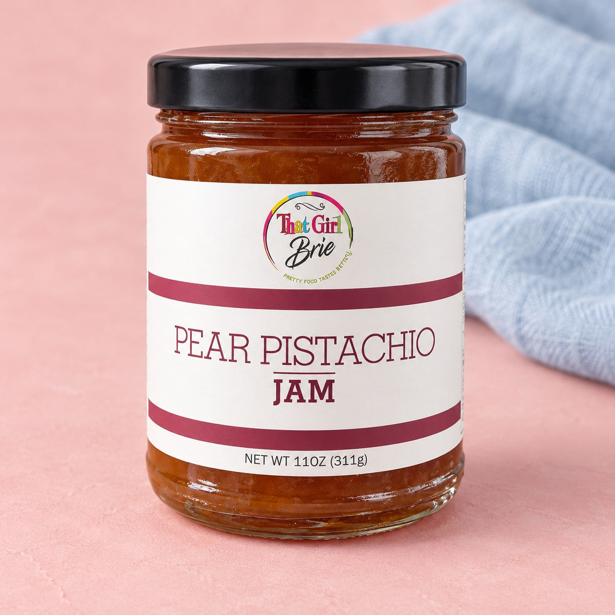 That Girl Brie Pear Pistachio jam jar with a blue linen napkin