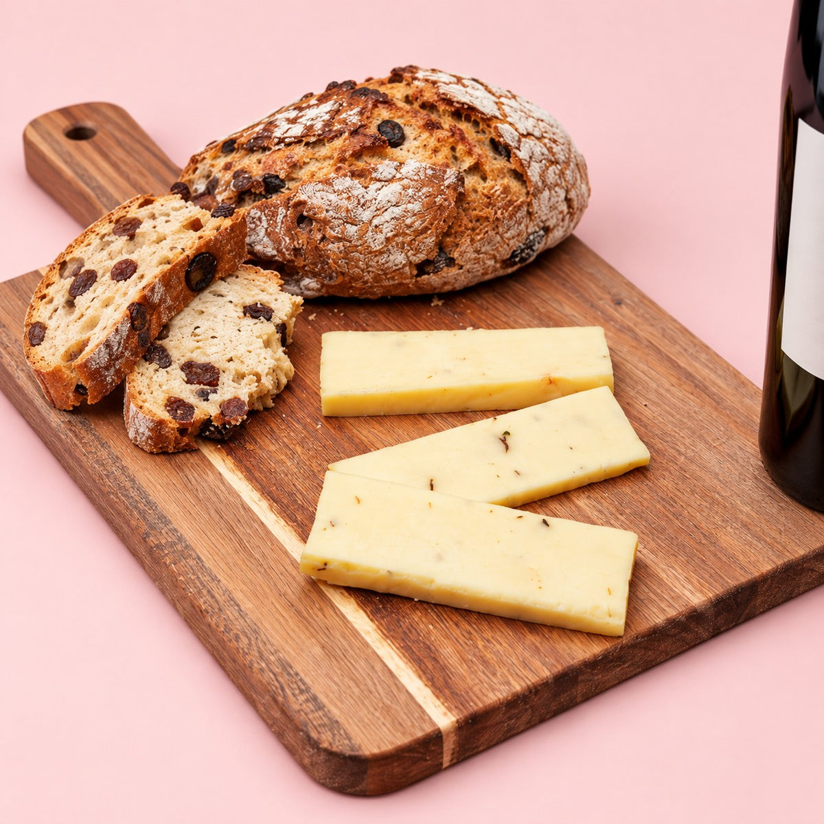 Portabella & Chive mushroom cheese sliced on a wooden board with raisin bread and red wine