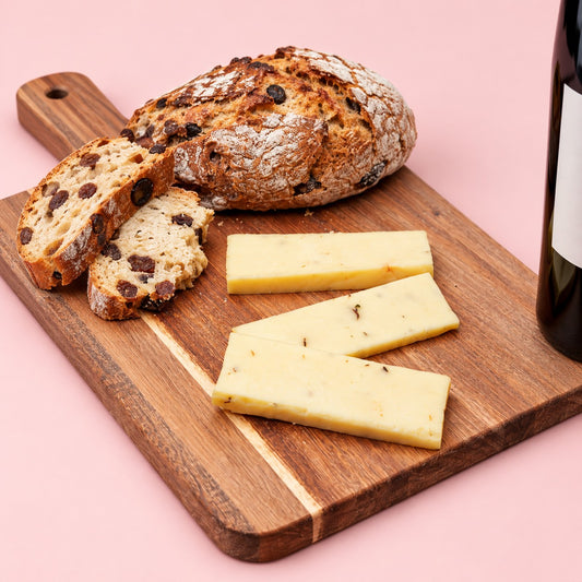 Portabella & Chive mushroom cheese sliced on a wooden board with raisin bread and red wine