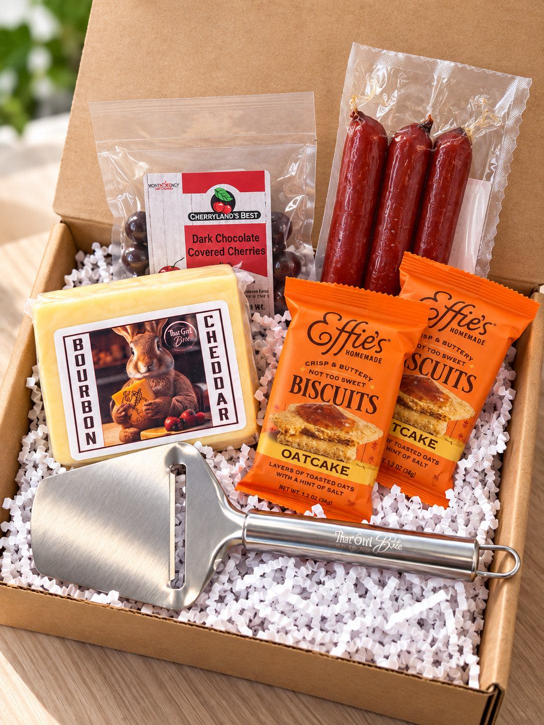 The Wisconsin Nightcap, a Wisconsin gift basket with Bourbon Cheddar, snack sticks, oatcakes and a cheese slicer