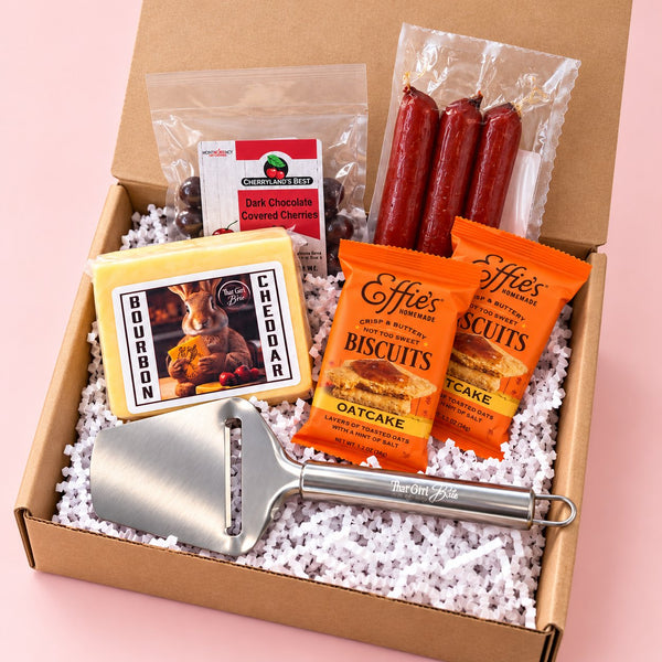 The Wisconsin Nightcap Wisconsin gift basket with Bourbon Cheddar, Udder Hills maple snack sticks, chocolate cherries, Effie's Oatcakes and a cheese slicer